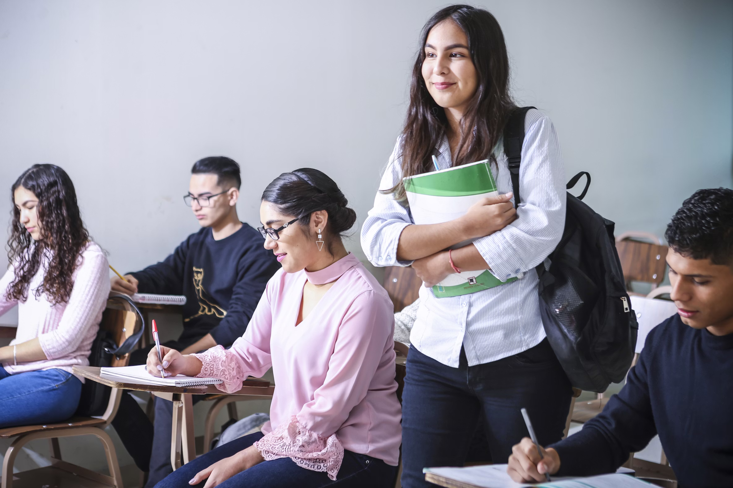 Students planning their student loan payoff strategy with notes and a calculator