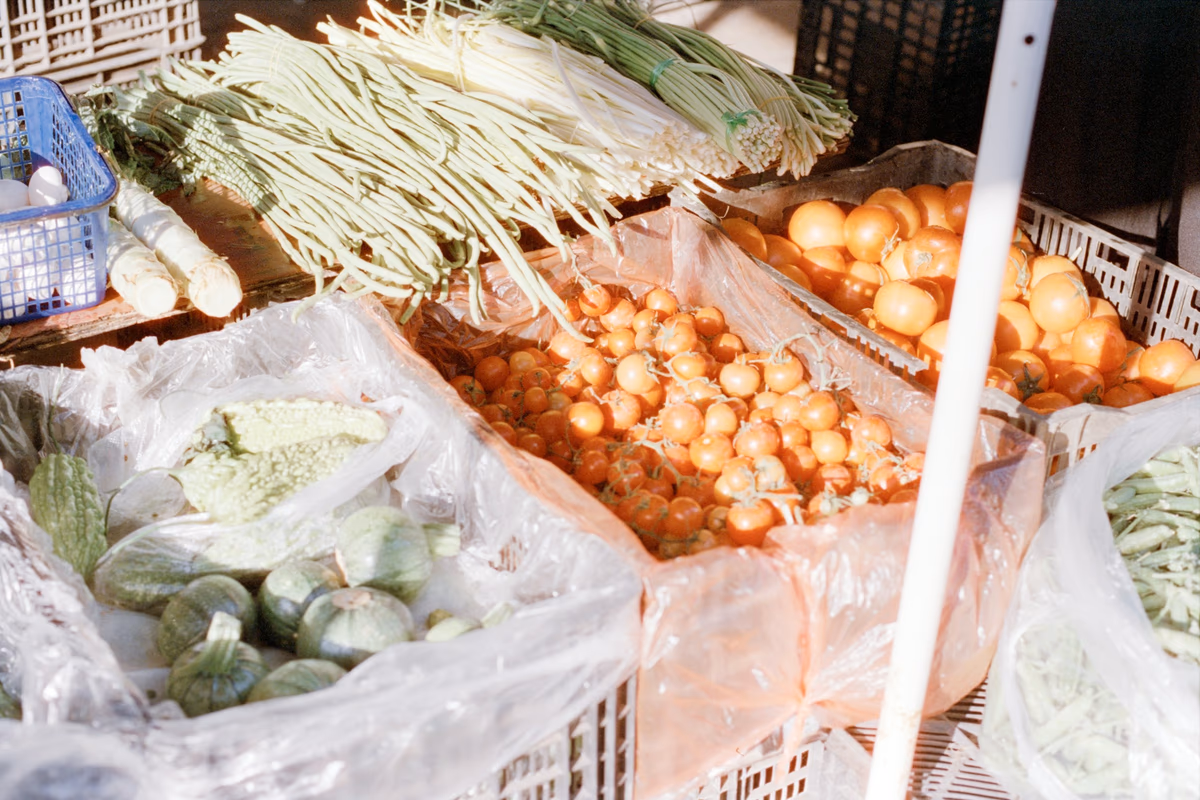 Fresh vegetables and fruits displayed in wooden crates at a market
